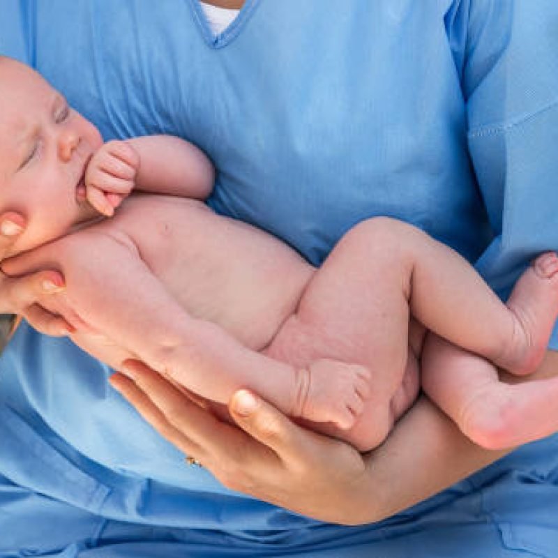 Doctor holding a beautiful newborn baby in hands